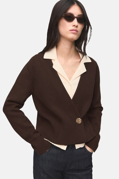 Gilet marron by MANGO, bouton doré, porté sur une chemise beige et un jean foncé.