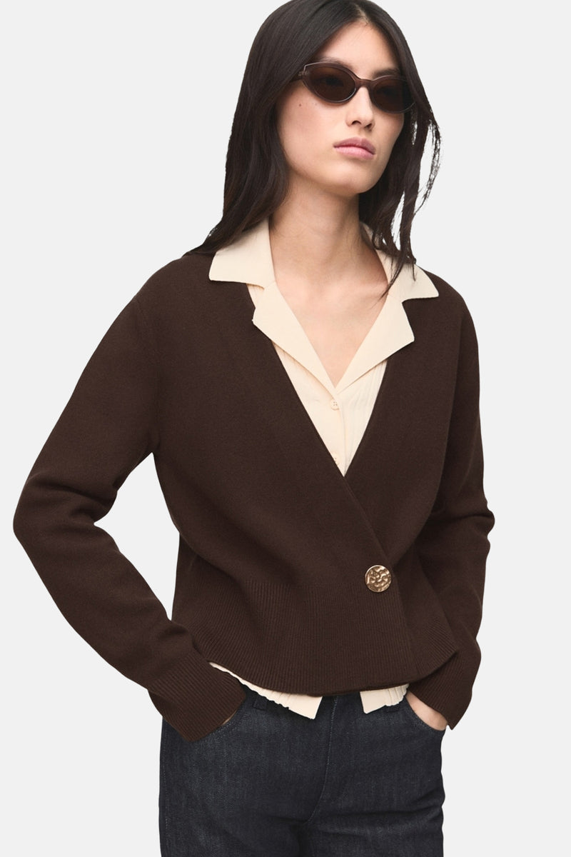 Gilet marron by MANGO, bouton doré, porté sur une chemise beige et un jean foncé.