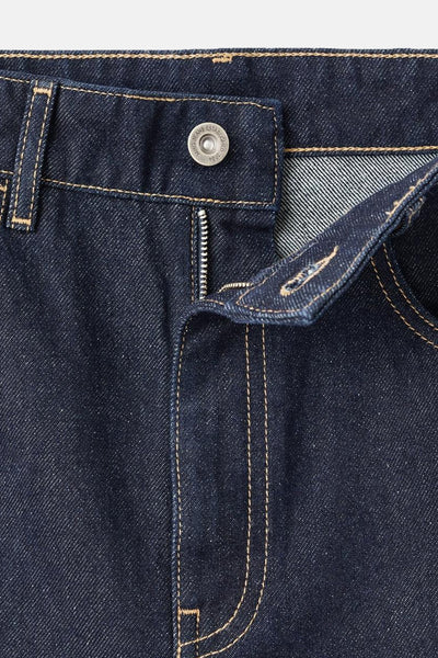 Jean en denim bleu foncé de MANGO, avec fermeture éclair et surpiqûres contrastantes.