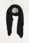 Écharpe noire en tricot par Pieces, texture douce et motif texturé, sur fond blanc.
