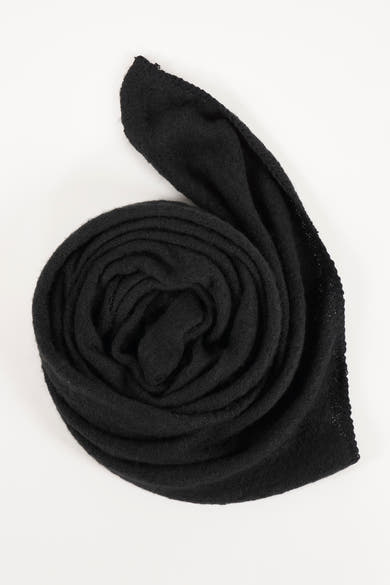 Écharpe noire de PIECES®, tricotée avec une texture douce, enroulée sur un fond blanc.
