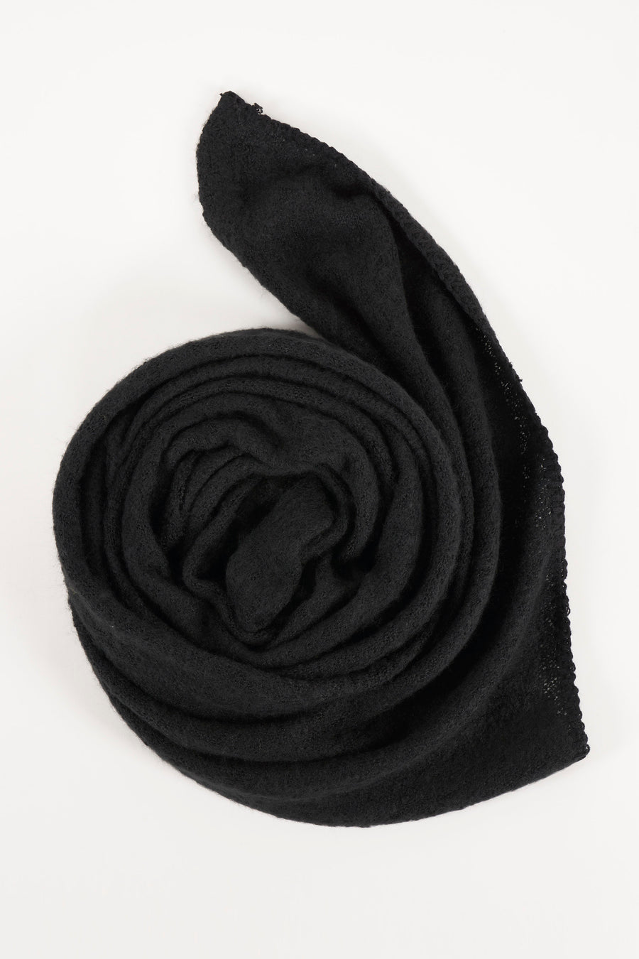 Écharpe noire de PIECES®, tricotée avec une texture douce, enroulée sur un fond blanc.
