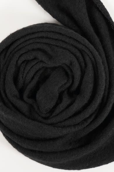 Écharpe noire enroulée de PIECES®, texture tricotée douce visible.