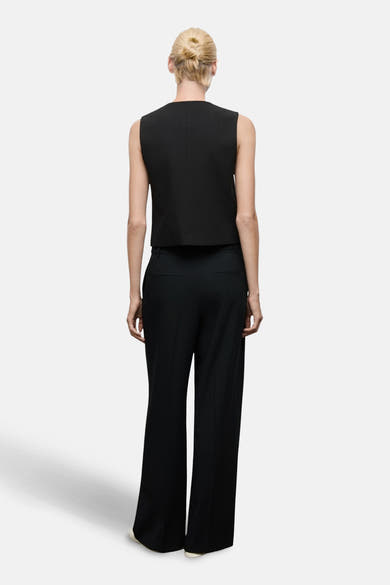 Pantalon noir de MANGO, coupe ample et taille haute, vue de dos.