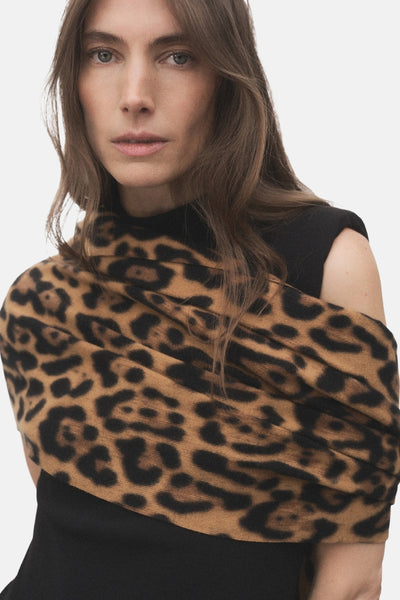 Multikleurige sjaal van MANGO, bruin en zwart luipaardmotief, gedrapeerd over een zwarte top.