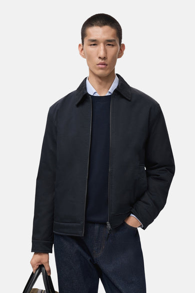 Korte blauwe jas van MANGO, gedragen over een trui en een overhemd, met een donkere jeans.
