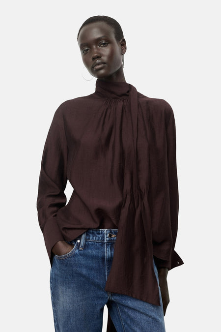 Bruin overhemd met lange mouwen van MANGO, met een uitsnede aan de achterkant, gedragen met een blauwe jeans.