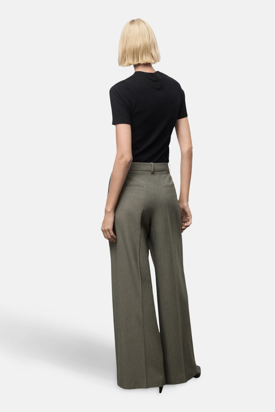 Pantalon vert par MANGO, coupe ample à jambes larges, vu de dos avec un t-shirt noir.