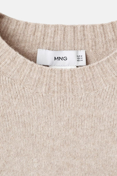 Pull à col rond beige de MANGO, en maille côtelée fine, avec une étiquette de taille visible.

