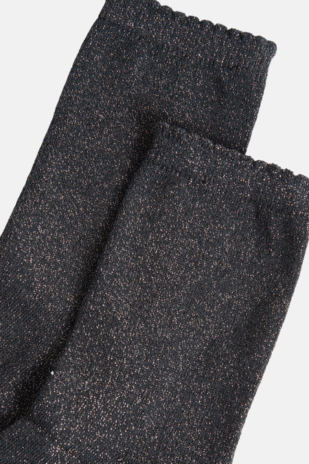 Chaussettes grises scintillantes de PIECES®, détail de texture tricotée avec bords ondulés.