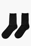 Chaussettes noires by PIECES®, avec bordure ondulée et texture scintillante, présentées côte à côte.
