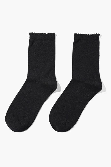 Chaussettes noires à paillettes de PIECES®, avec bordure ondulée décorative et détails scintillants.