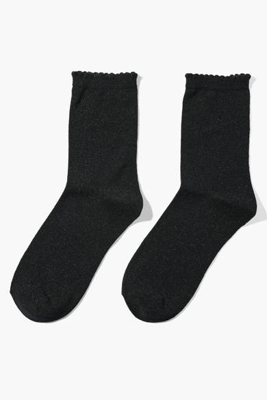 Chaussettes noires scintillantes de PIECES®, avec bordure ondulée, présentées côte à côte sur fond blanc.