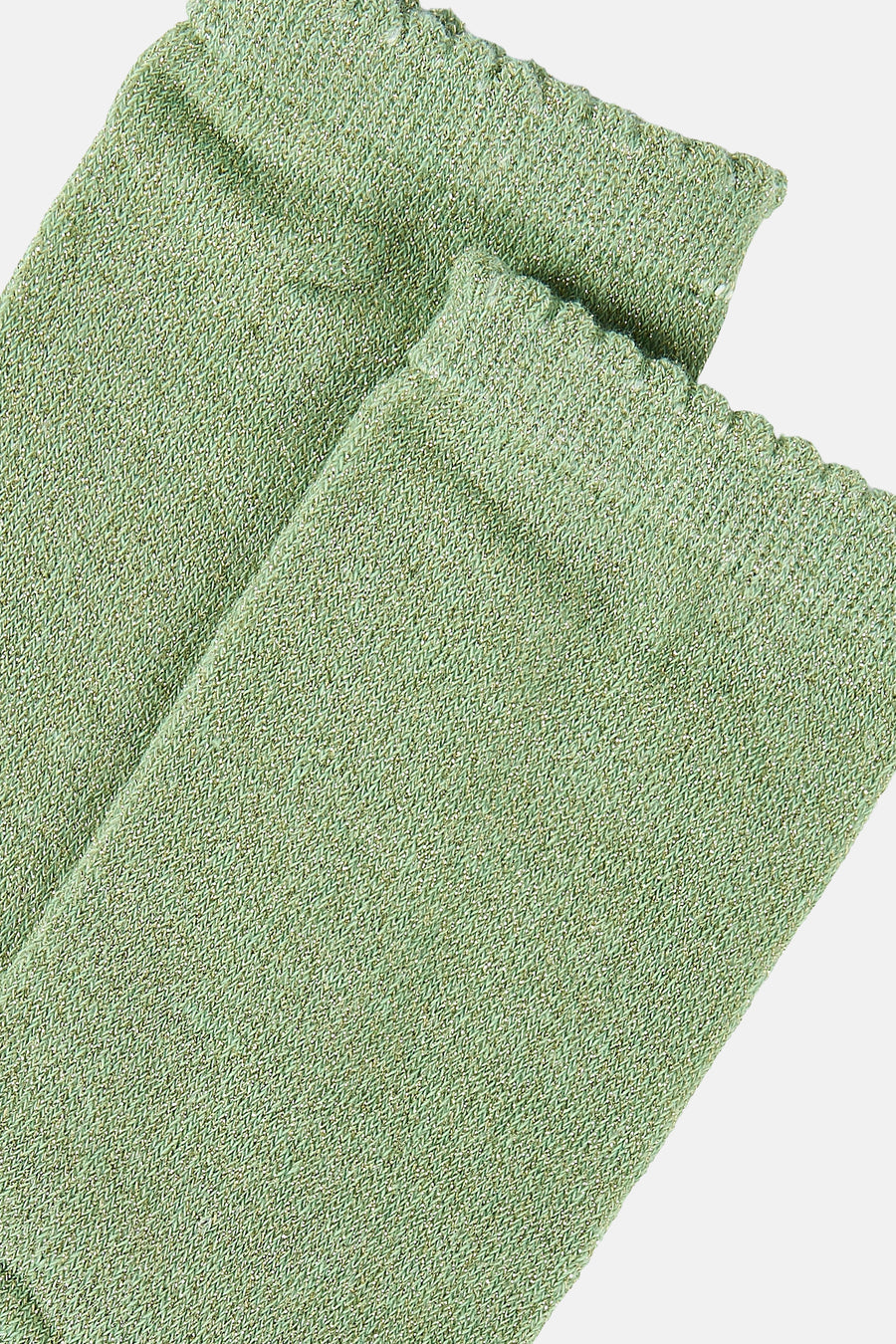 Chaussettes vertes de PIECES®, en maille brillante avec bordure ondulée, présentées en angle.
