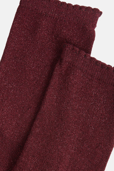 Chaussettes rouges à paillettes by PIECES® avec bordure ondulée et texture tricotée.