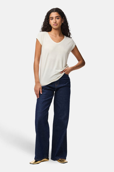 T-shirt blanc à manches courtes de PIECES®, porté avec un jean ample et des chaussures dorées.
