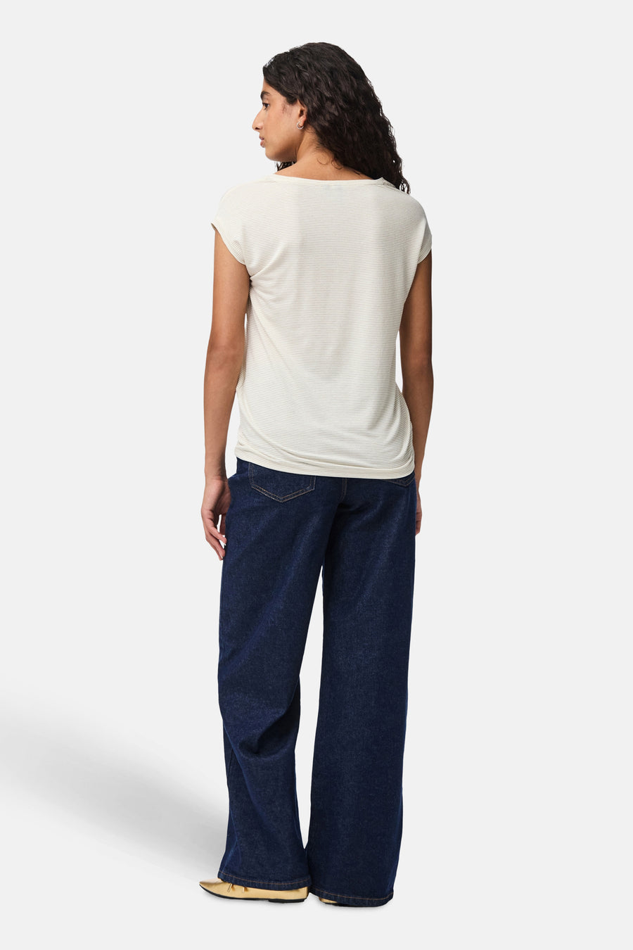 T-shirt blanc à manches courtes par Pieces, avec un motif rayé subtil et porté avec un jean large.