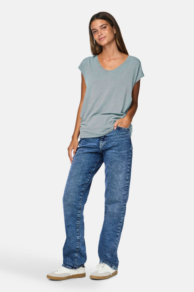 T-shirt à manches courtes bleu clair de Pieces, avec un motif rayé discret, porté avec un jean et des chaussures de sport.
