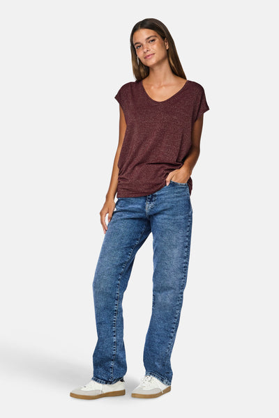 T-shirt bordeaux à manches courtes de PIECES, porté avec un jean bleu et des baskets blanches.