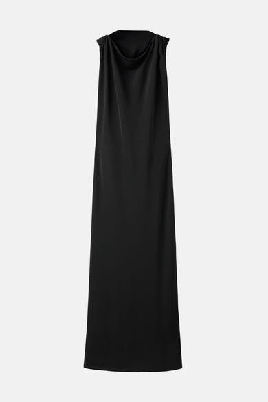 Zwarte jurk van MANGO, halternek met gouden ringdetail, gedragen met lange zwarte handschoenen.