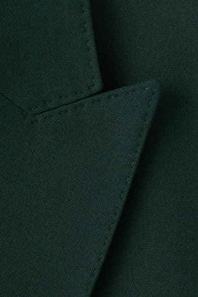 Groene blazer van MANGO, zichtbare stikseldetails en getextureerde stof.