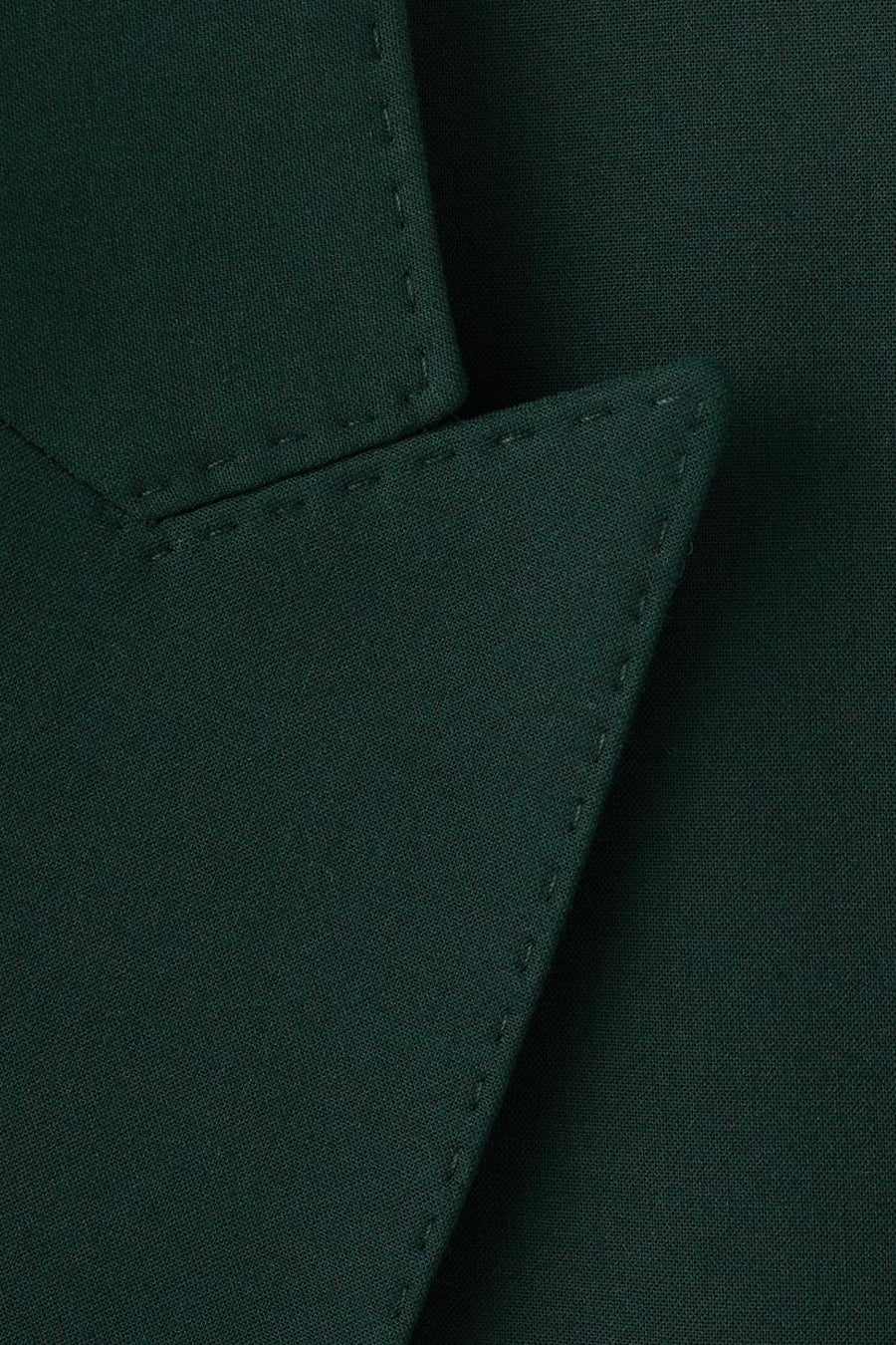 Groene blazer van MANGO, zichtbare stikseldetails en getextureerde stof.