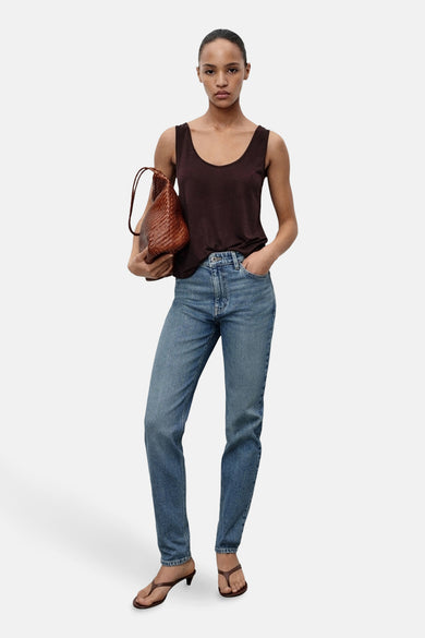 Mom jeans in middinblauw denim van MANGO, gedragen met een bruine top en sandalen met hak.