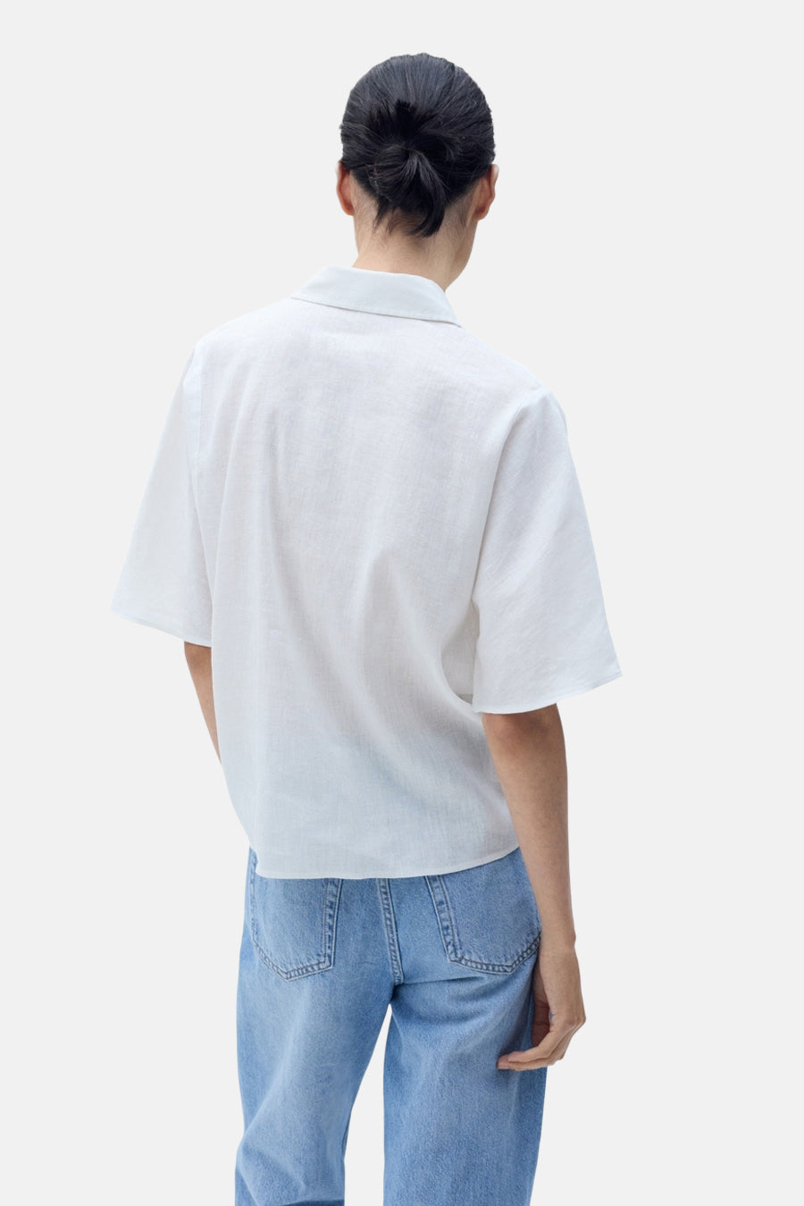 Witte blouse met korte mouwen van MANGO, rugdetail, gedragen met een lichtblauwe jeans.