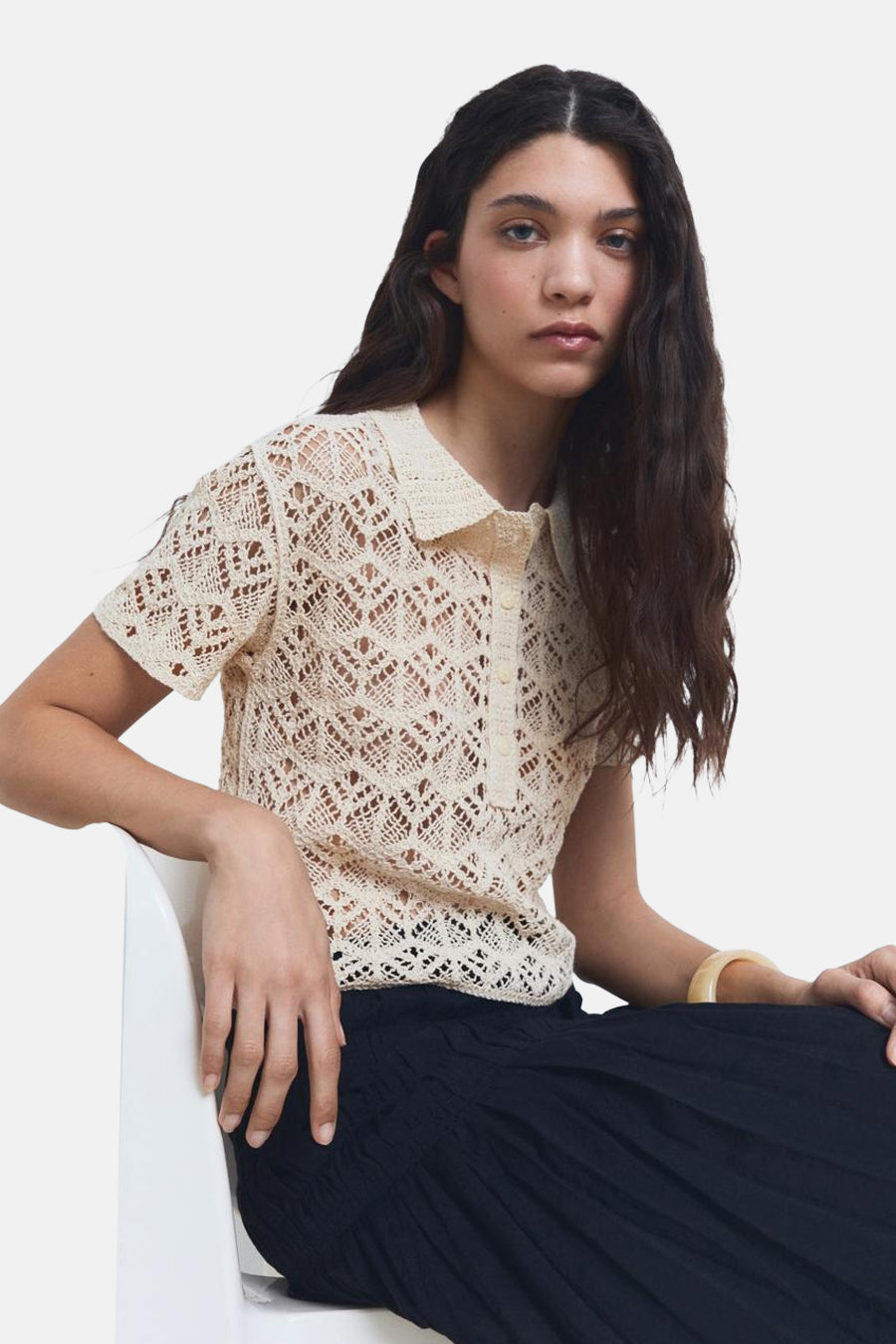 Beige ronde hals trui van MANGO, in gehaakt ajourpatroon, gedragen met een zwarte rok.
