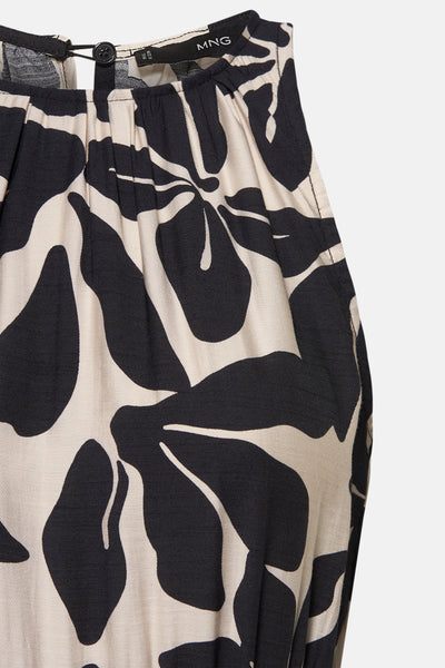 Zwarte jumpsuit met bloemenprint van MANGO, met een knoop en plooien bij de halslijn.