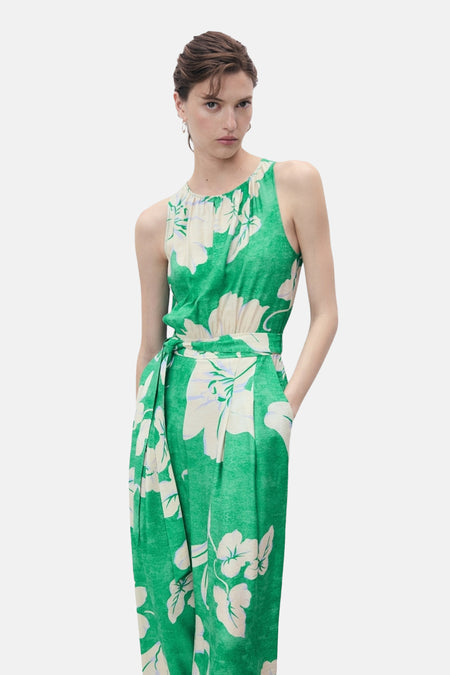 Groene jumpsuit van MANGO, witte bloemenprint en strikdetail in de taille.
