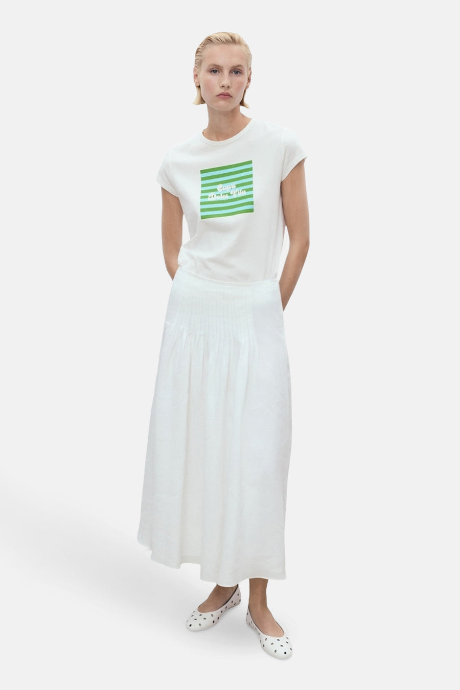 Wit T-shirt met korte mouwen van MANGO met een groen gestreept patroon op de voorkant, gedragen met een witte rok.