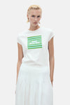 Wit T-shirt met korte mouwen van MANGO, met groene en blauwe strepenprint en motief op de voorkant, gedragen met een witte plooirok.