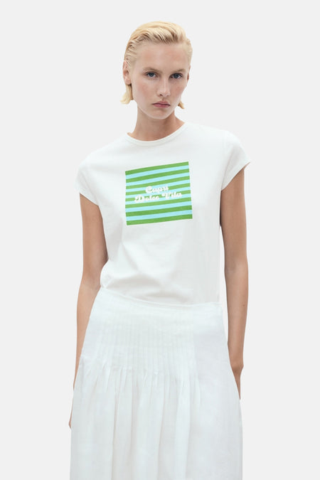 Wit T-shirt met korte mouwen van MANGO, met groene en blauwe strepenprint en motief op de voorkant, gedragen met een witte plooirok.
