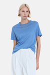 Blauw T-shirt met korte mouwen van MANGO, gedragen met een witte broek met hoge taille en een zilveren ketting.
