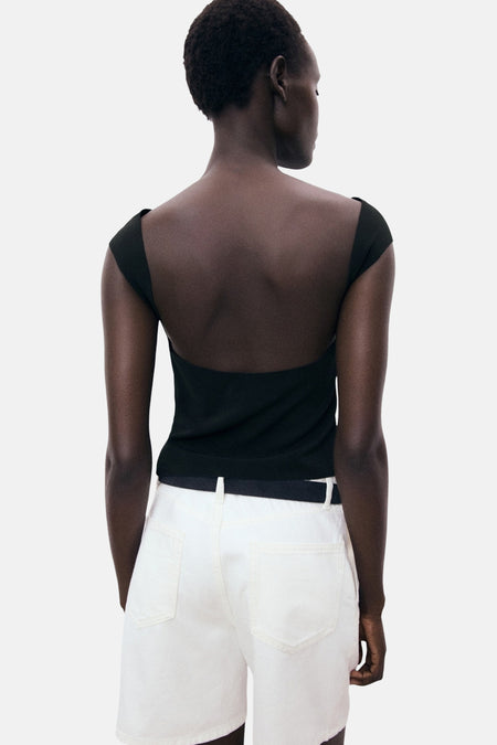 Zwart T-shirt met korte mouwen van MANGO, gedragen met een witte short met hoge taille en zwarte riem.