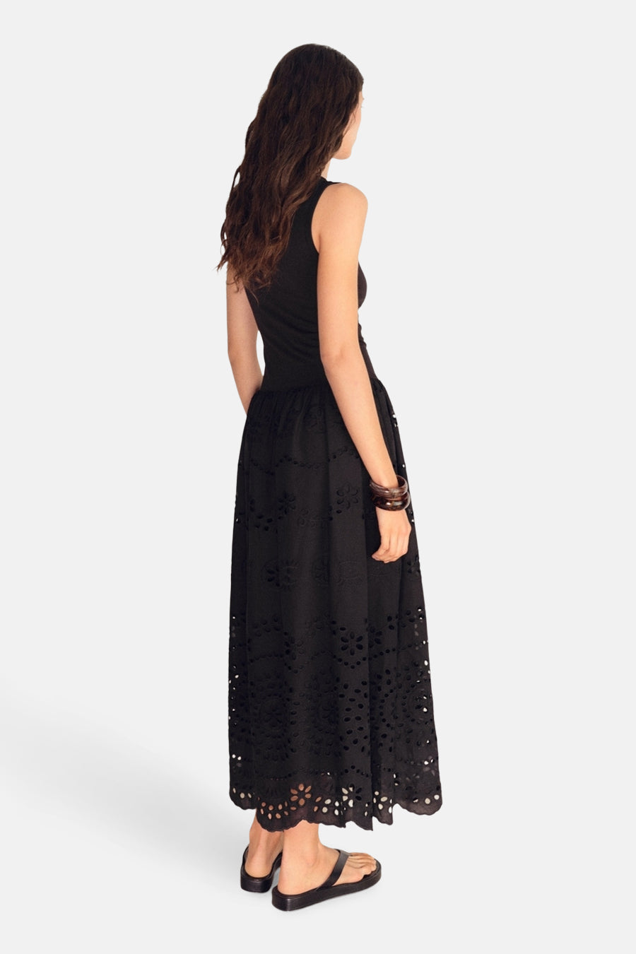 Zwarte jurk van MANGO, met lange rok geborduurd met bloemenmotieven, gedragen met zwarte sandalen.