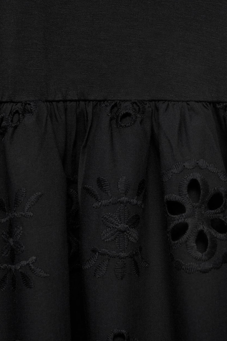 Zwarte jurk van MANGO met geborduurde bloemdetails en uitgesneden details op de uitlopende rok.