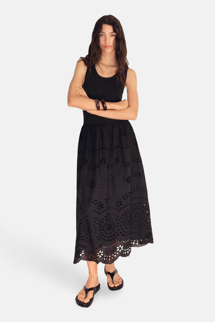 Zwarte jurk van MANGO, lang met bloemige uitgesneden details en gedragen met een zwarte tanktop en sandalen.