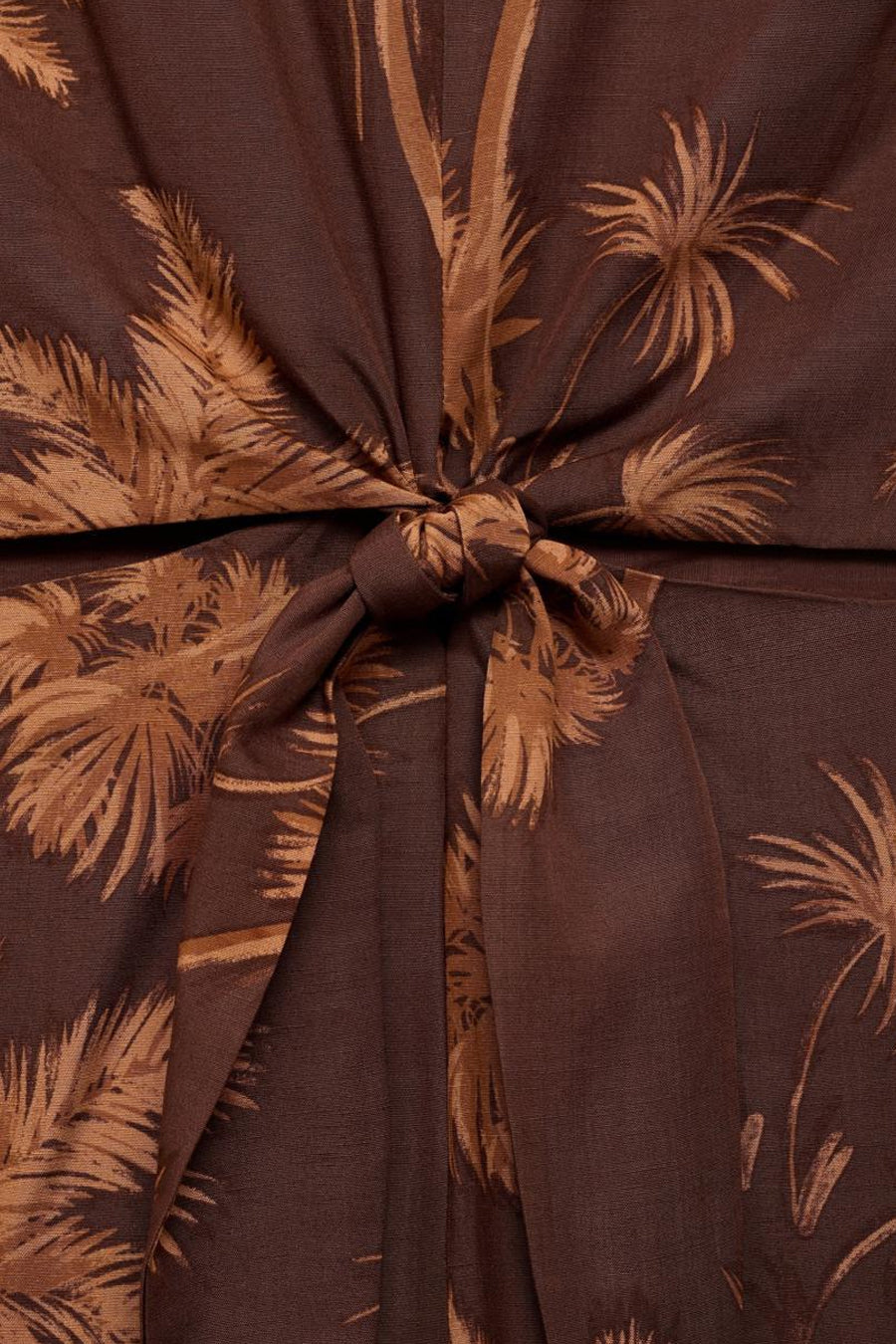 Bruin MANGO jumpsuit met palmboomprint en decoratieve strik in de taille.