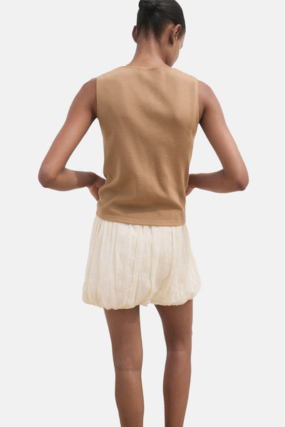 Bruin gilet van MANGO, gedragen met een gebroken witte ballonrok, van achteren gezien.