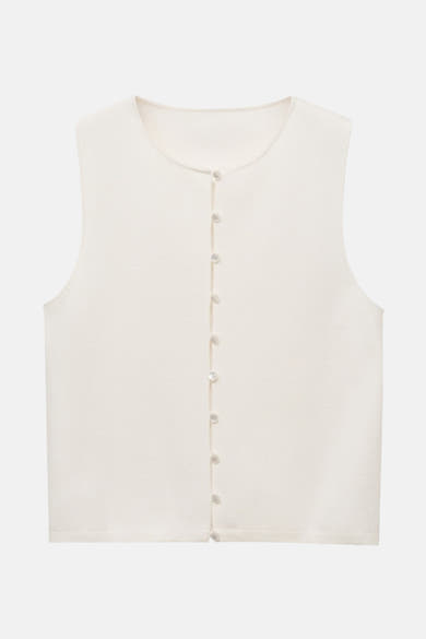 Gilet blanc de MANGO avec une rangée de boutons nacrés sur fond uni.