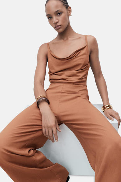 Bruin jumpsuit van MANGO, met een gedrapeerd bovenstuk en gouden accessoires.