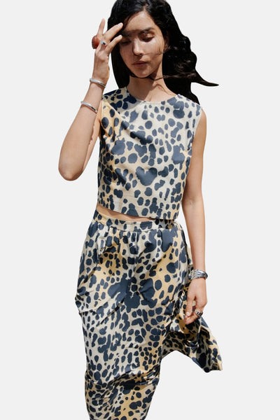 Beige mouwloos overhemd van MANGO, luipaardprint, gedragen met een bijpassende rok en zilveren sieraden.