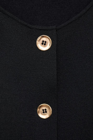 Zwarte blouse van MANGO met twee gouden knopen aan de voorkant.