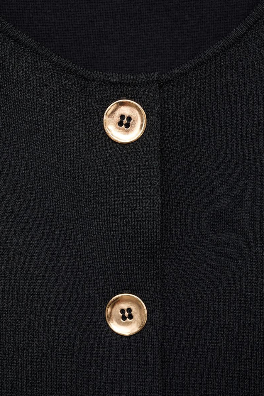 Zwarte blouse van MANGO met twee gouden knopen aan de voorkant.