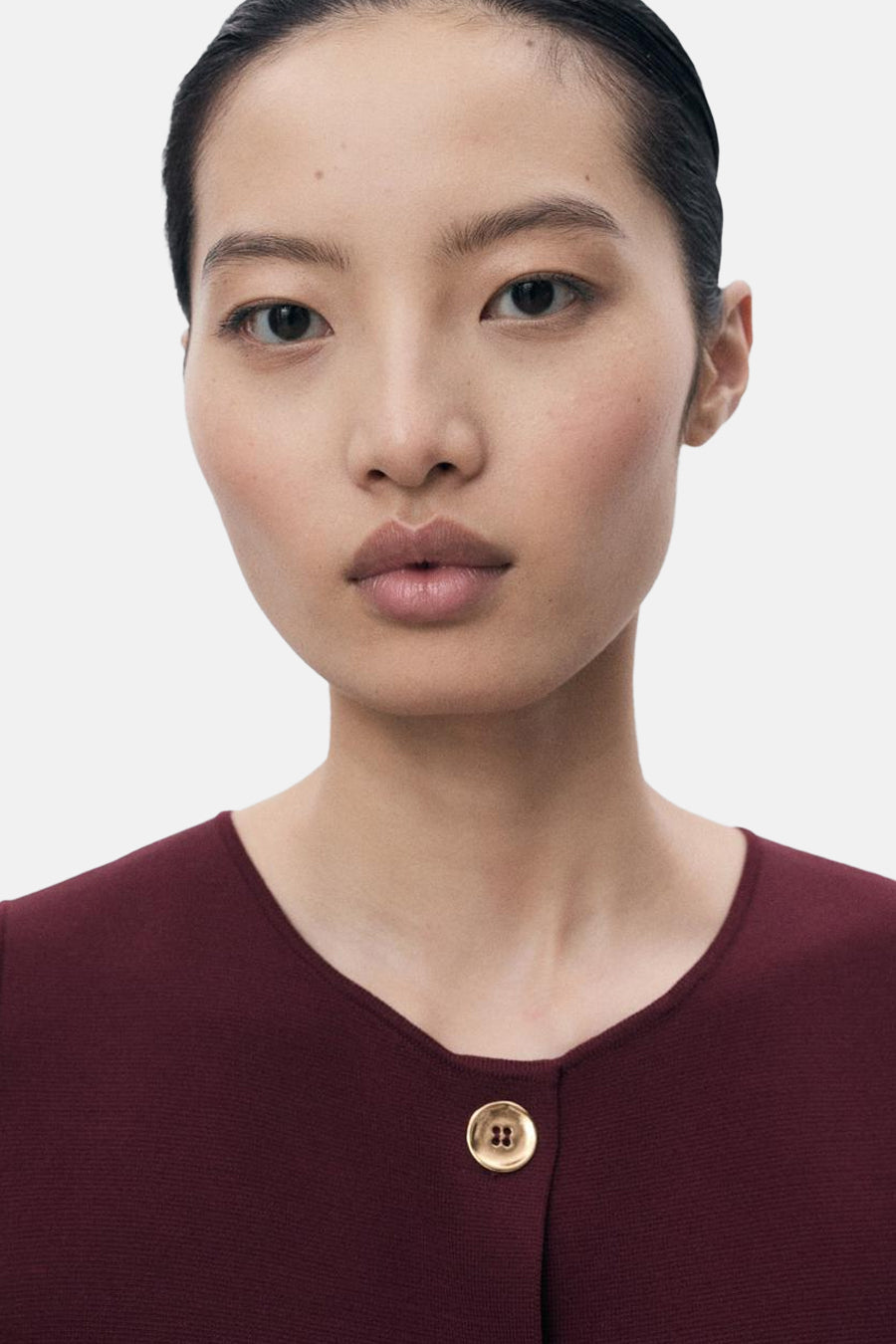 Bordeaux blouse van MANGO met een gouden knoop, ronde hals en aansluitende pasvorm.