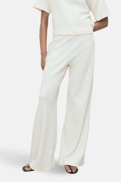 Witte broek van MANGO, wijde pasvorm, met bijpassend topje, achterzicht.
