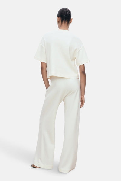 Pantalon blanc de MANGO, coupe ample, avec un haut assorti, vue de dos.

