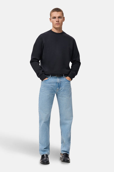 Blauwe trui van MANGO, gedragen met een verbleekte spijkerbroek en zwarte leren schoenen.